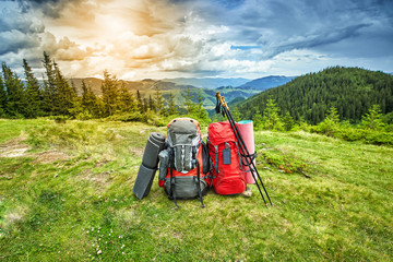 Backpacks in the mountains overlooking the mountains on the green grass.