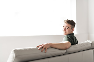 Handsome confident young man relaxing at home on the sofa