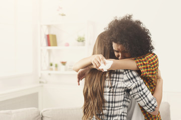 Woman hugging her depressed friend at home