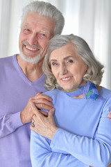 happy senior couple hugging at home