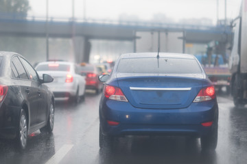 Fototapeta na wymiar cars in traffic jam on wet road at rainy city evening
