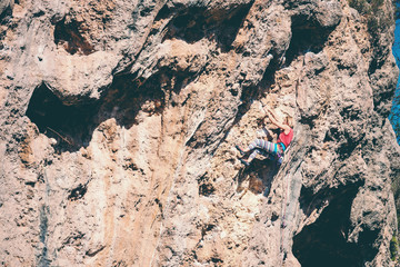 A woman climbs the rock.