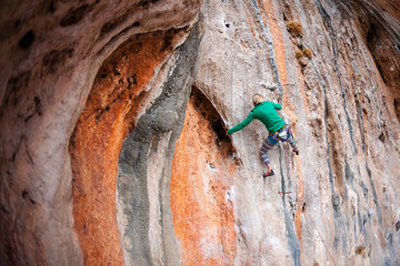 A woman climbs the rock.