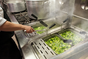 Chef prepares green broccoli in boiling water