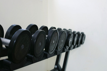 Fototapeta na wymiar selective focus rows of dumbbells on rack for weight training workout in fitness gym, equipment, bodybuilder, healthy lifestyle, exercise and sport training concept