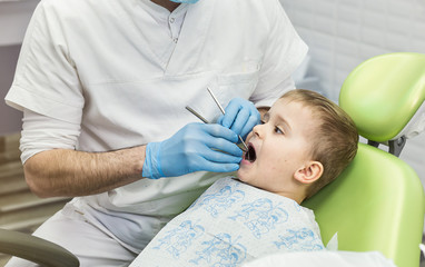 Obraz na płótnie Canvas Dentist examining little boy's teeth in clinic. Dental problem.