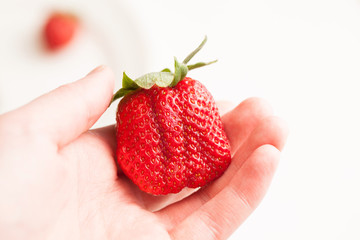 Ripe red strawberry on white table