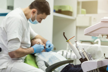Fototapeta premium Dentist examining little boy's teeth in clinic. Dental problem.
