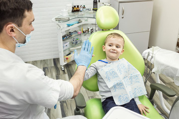 Dentist examining little boy's teeth in clinic. Dental problem.