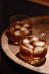 Glass of whiskey on wooden background close up