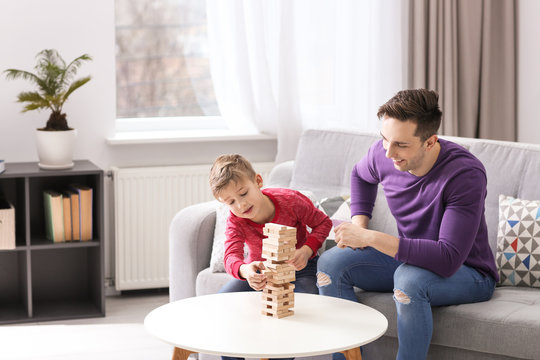 Dad and his son playing board game at home