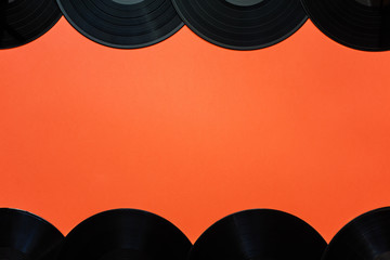 Top view of vinyl records up and down on orange background