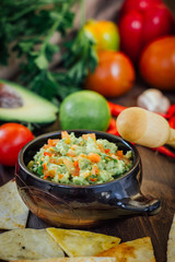 Guacamole with corn chips - nachos, made from avocado, tomatoes and lime.