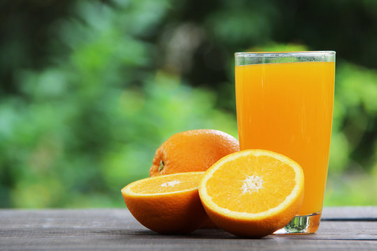 Orange juice and oranges, selective focus.