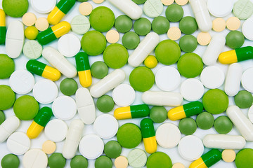 Multicolored pills on white background