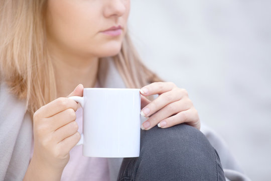 Close up portrait of woman drinking coffee in chilly morning 
