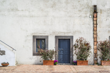 Typisch meditarrene weiße Wand mit blauer Tür und Pflanzen