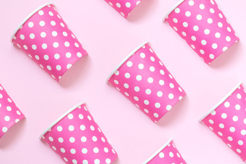 Diagonally positioned paper cups isolated on pink background. Minimalistic fashionable concept.