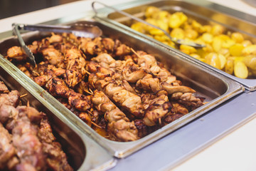 Beautifully decorated catering banquet table with different main course hot food dishes and garnish, with rice, chicken, lamb, vegetables and kebab on corporate party event or wedding celebration