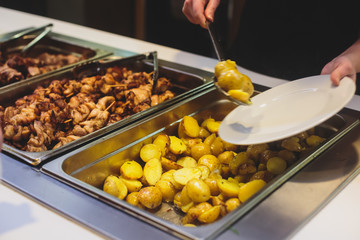 Beautifully decorated catering banquet table with different main course hot food dishes and garnish, with rice, chicken, lamb, vegetables and kebab on corporate party event or wedding celebration