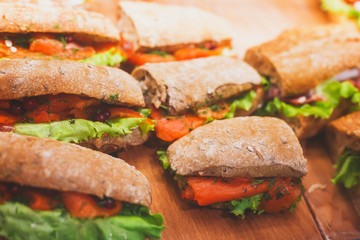 Beautifully decorated catering banquet table with different food snacks and appetizers with sandwich, on corporate christmas birthday kids party event or wedding celebration