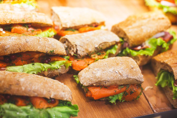 Beautifully decorated catering banquet table with different food snacks and appetizers with sandwich, on corporate christmas birthday kids party event or wedding celebration