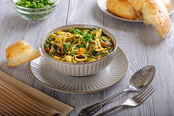 Soup lagman on a wooden table.