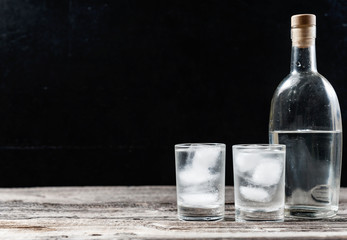 Cold vodka in shot glasses on a black background