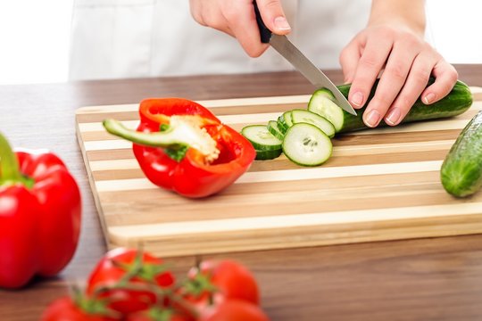 Chef woman cutting cucumber