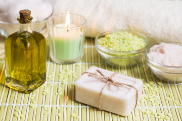 Fototapeta na wymiar Spa setting with natural soap, olive oil, bath salts and candle. Wellnes concept.