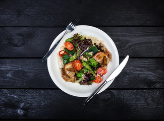 Salad with fried quail with tomatoes and lettuce.