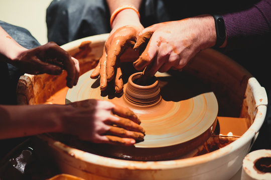 A process of pottery, with two people involved, working on pottery wheel and making clay pot