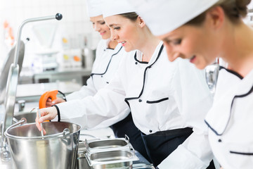 Team of happy chefs in production process of system catering