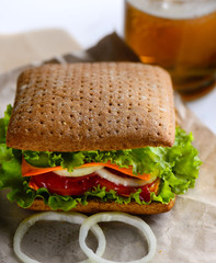 Sandwich with grain bread in and beer on white background