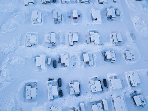 Aerial winter view of camping place with caravans, trailer park and cabin cottage houses, northern Sweden, near border with Norway