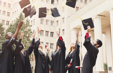 A group of graduates throwing graduation caps in the air