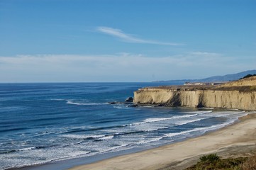 Beautiful scenic coastal view in California (USA): Untouched nature of the pacific ocean with limestone rock cliffs and crashing waves with a clear blue summer sky create the perfect picturesque place