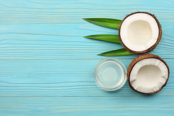 Coconut with green leaves on blue wooden background. top view with copy space