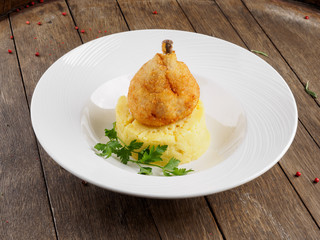 Restaurant dish. Chicken cutlet on a bone with mashed potatoes and a leaf of parsley.