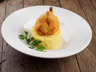 Restaurant dish. Chicken cutlet on a bone with mashed potatoes and a leaf of parsley.