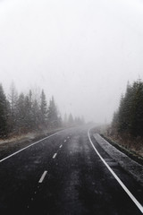 Blurry dangerous car overtaking on highway at heavy snowy conditions. traffic situation, marks, Problems, vertical photo