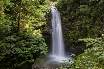 Fototapeta na wymiar Palovit Waterfall in Kaçkar Mountains National Park is one of the highest waterfalls of Rize. This famous waterfall in a lush green forest is about 15 meters high and foam poured into a creek bed.
