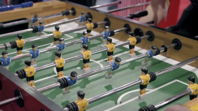 Handsome cheerful men having fun on event playing table soccer close up sport competition contest football