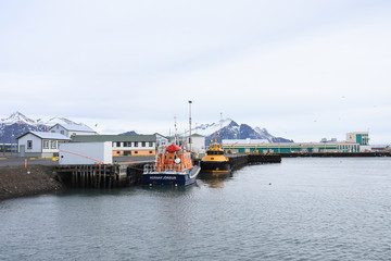 Fototapeta na wymiar Transportation ship park in Hornafjordur port, a blooming community in the realm of the greatest glacier in southeast Iceland.