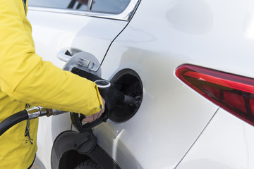 Close-up fuel nozzle with hand hold . Fill up fuel at gas station.