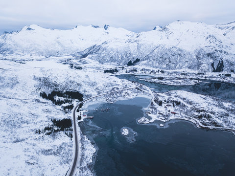 Aerial winter view of Lofoten Islands, Nordland, Norway, with fjord, road and mountains, shot from drone