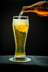 Filling glass glass with golden beer