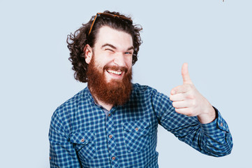 Happy bearded man pointing at the camera. Smiling hipster man with beard pointing at camera.