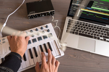 Musician is recording tunes on his computer music. first-person view