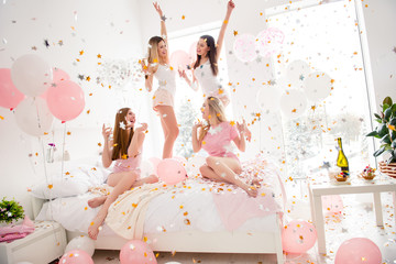 Cheerful, cool, sexy, pretty, charming, funky girls in night wear enjoying rain of colorful stars, confetti having theme party meeting indoor, drinking alcohol, dancing, laughing - obrazy, fototapety, plakaty